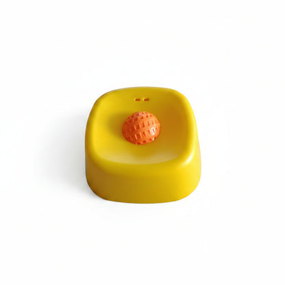 Yellow container with an orange ball on a white surface