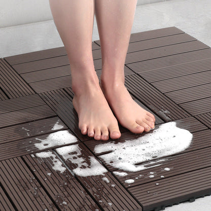 Person standing on a brown interlocking foam mat with soapy water splashes.