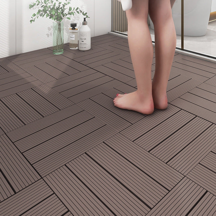 Wooden flooring tiles with a person standing on them, near a glass of water and bottles.