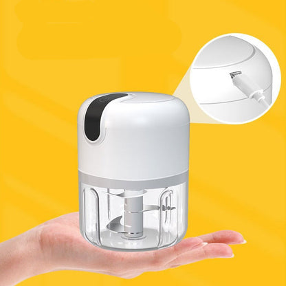 Small electric grinder held in a hand with yellow background.