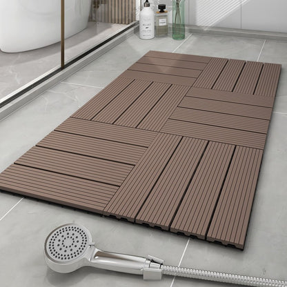 Brown interlocking shower mat on a tiled bathroom floor with a handheld shower head.